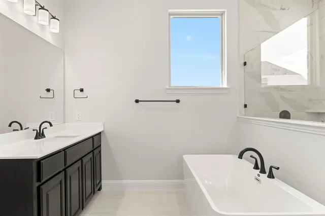 a spacious bathroom with a bathtub sink and mirror
