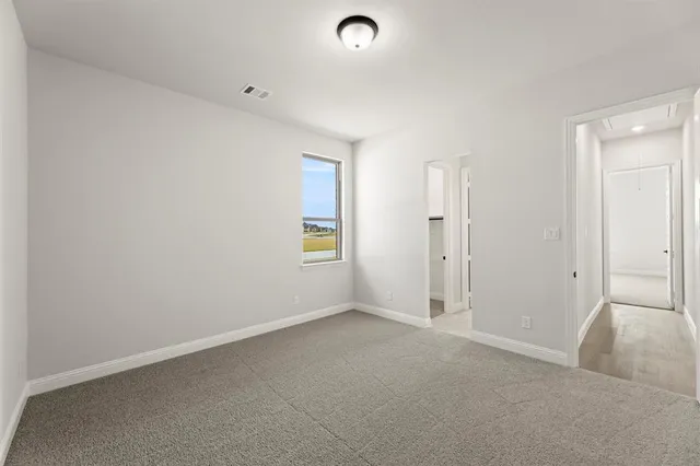 an empty room with windows and entrance to other room
