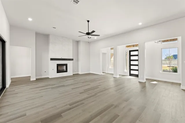 an empty room with windows and a fireplace