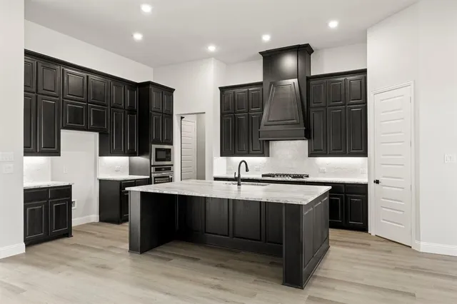 a kitchen with stainless steel appliances a sink and a refrigerator