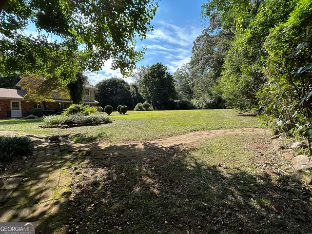 a view of a house with backyard and sitting area