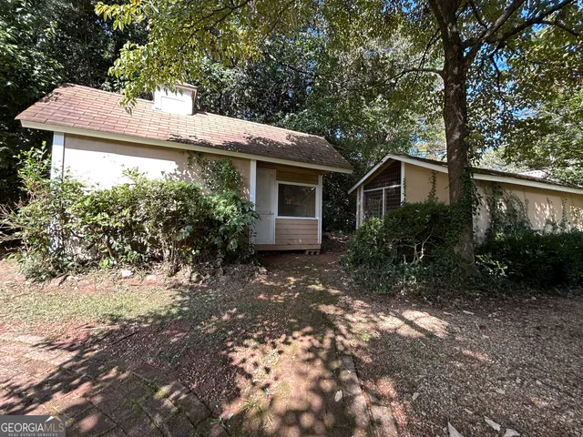 a view of a house with backyard and trees
