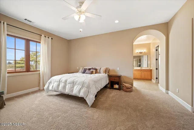 a spacious bedroom with a bed and a chandelier