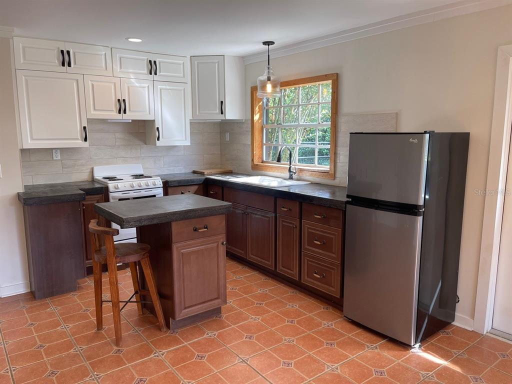 2309 Southwest 66th Street Ocala, FL 34476 - Photo 16 of 35 a kitchen with stainless steel appliances granite countertop a stove a refrigerator and a sink