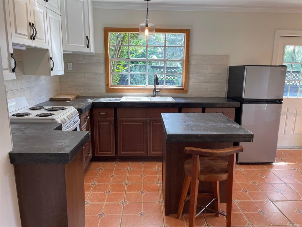 2309 Southwest 66th Street Ocala, FL 34476 - Photo 17 of 35 a kitchen with granite countertop a stove a sink and a refrigerator