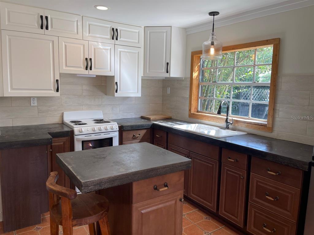 2309 Southwest 66th Street Ocala, FL 34476 - Photo 18 of 35 a kitchen with a stove a sink a center island and cabinets