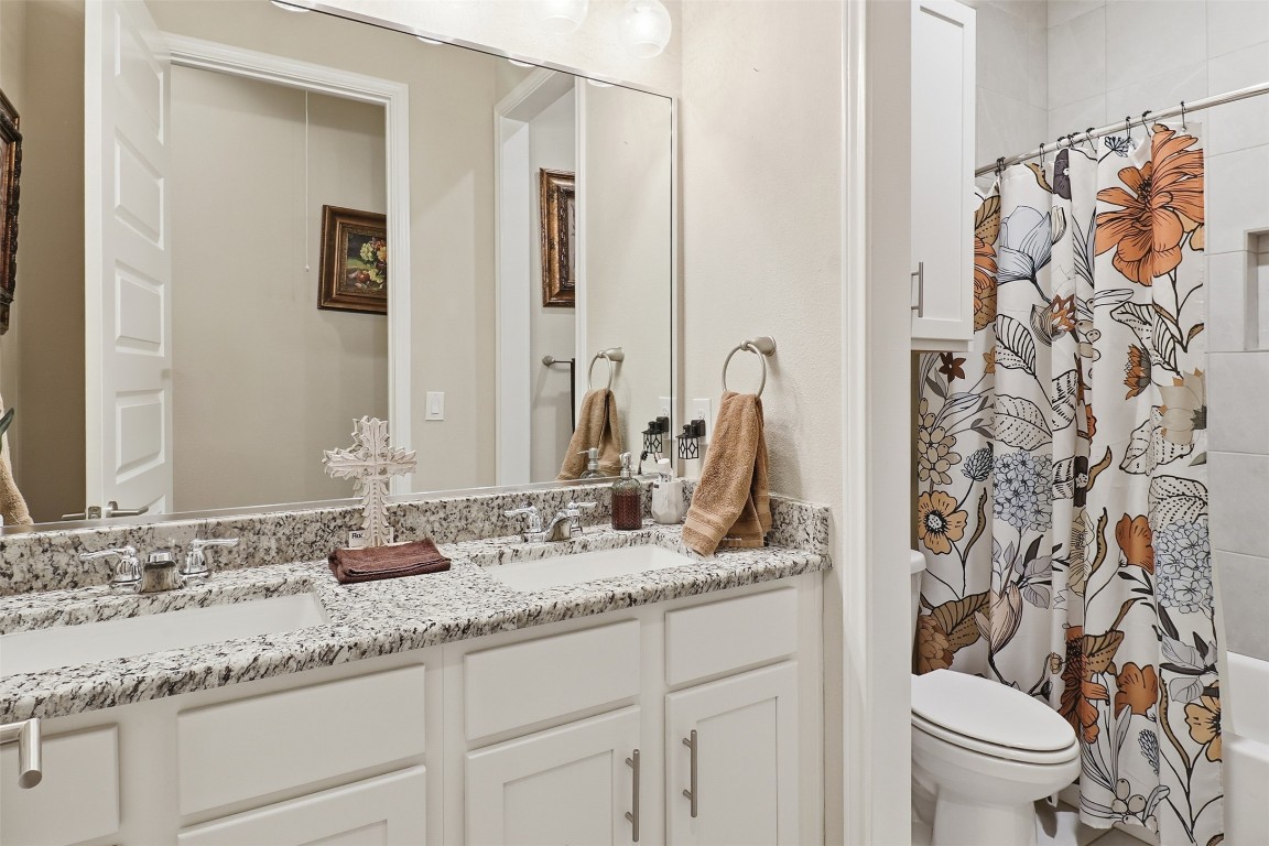 103 Kings Way Horseshoe Bay, TX 78657 - Photo 14 of 20 a bathroom with a granite countertop sink a toilet and a mirror