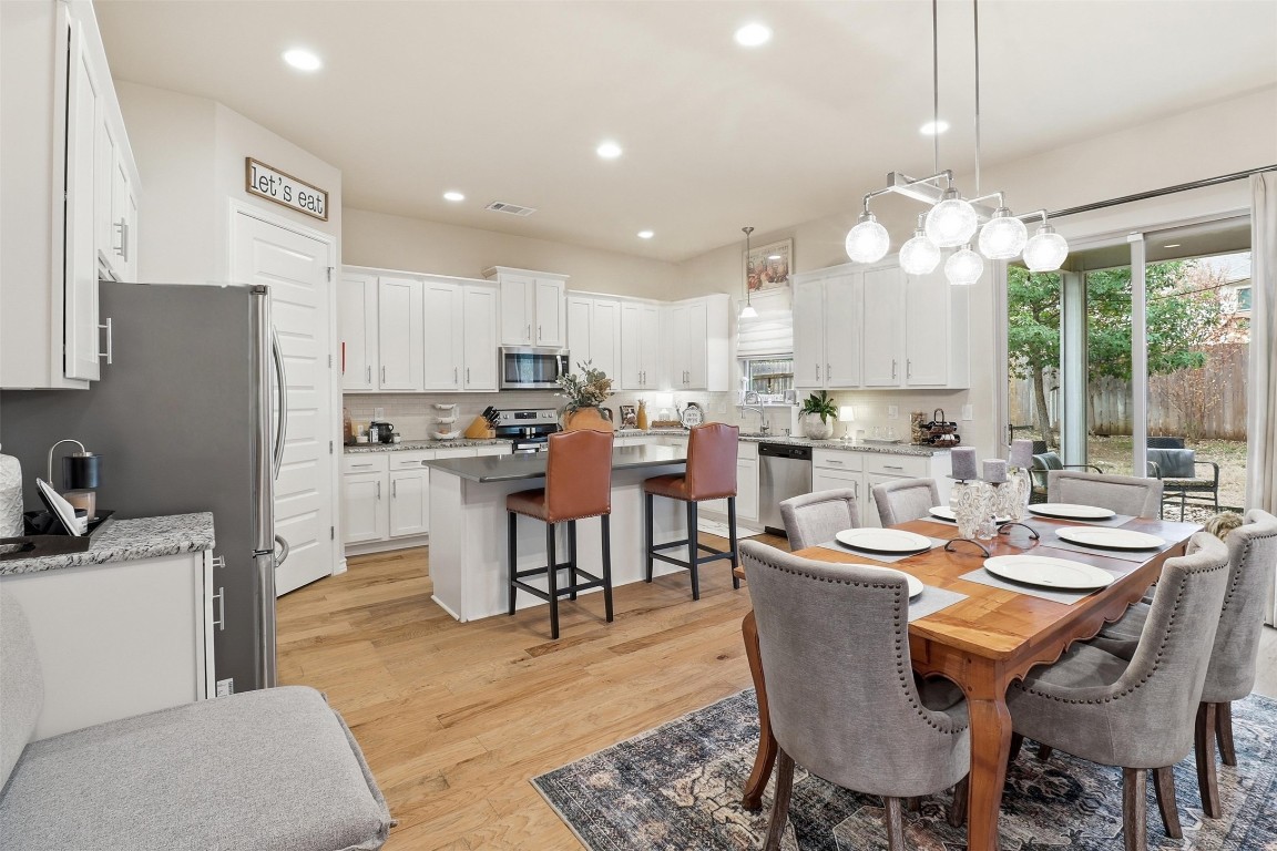 103 Kings Way Horseshoe Bay, TX 78657 - Photo 3 of 20 a dining room with stainless steel appliances kitchen island granite countertop a dining table chairs and a refrigerator