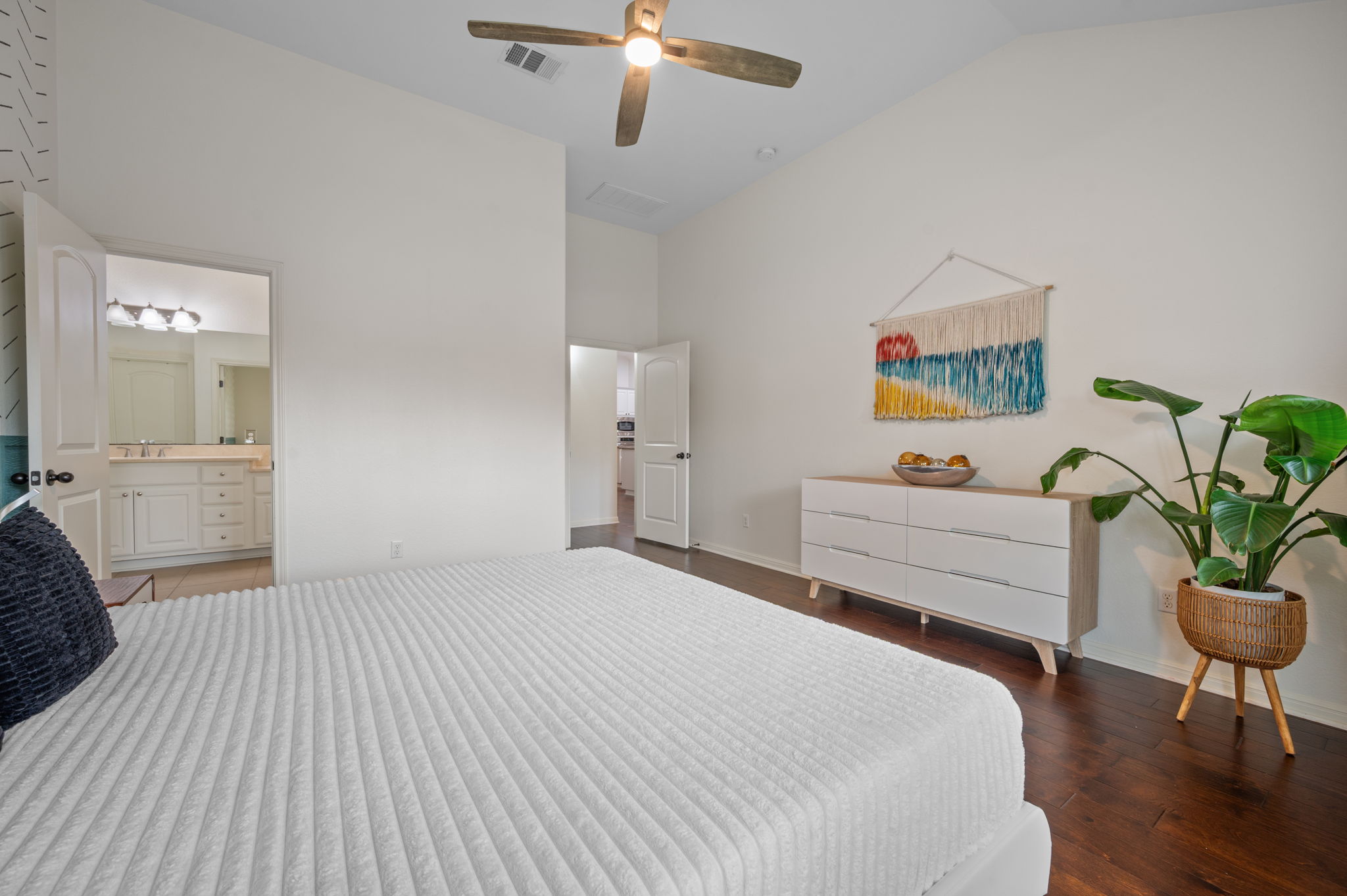 4220 Tambre Bend Austin, TX 78738 - Photo 17 of 28 Bedroom with vaulted ceiling, ceiling fan, dark wood-style flooring, and connected bathroom