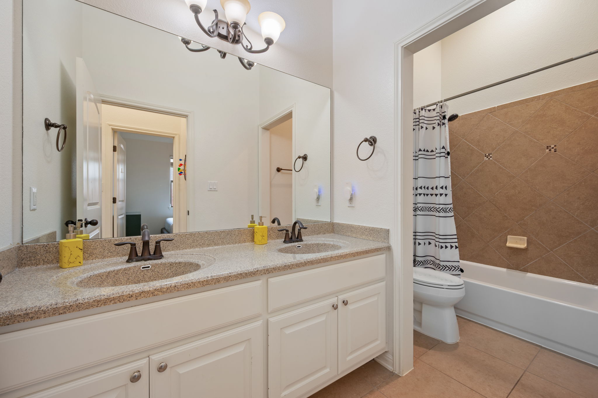 4220 Tambre Bend Austin, TX 78738 - Photo 21 of 28 Bathroom with double vanity, light tile patterned flooring, shower / tub combo with curtain, and hanging lights