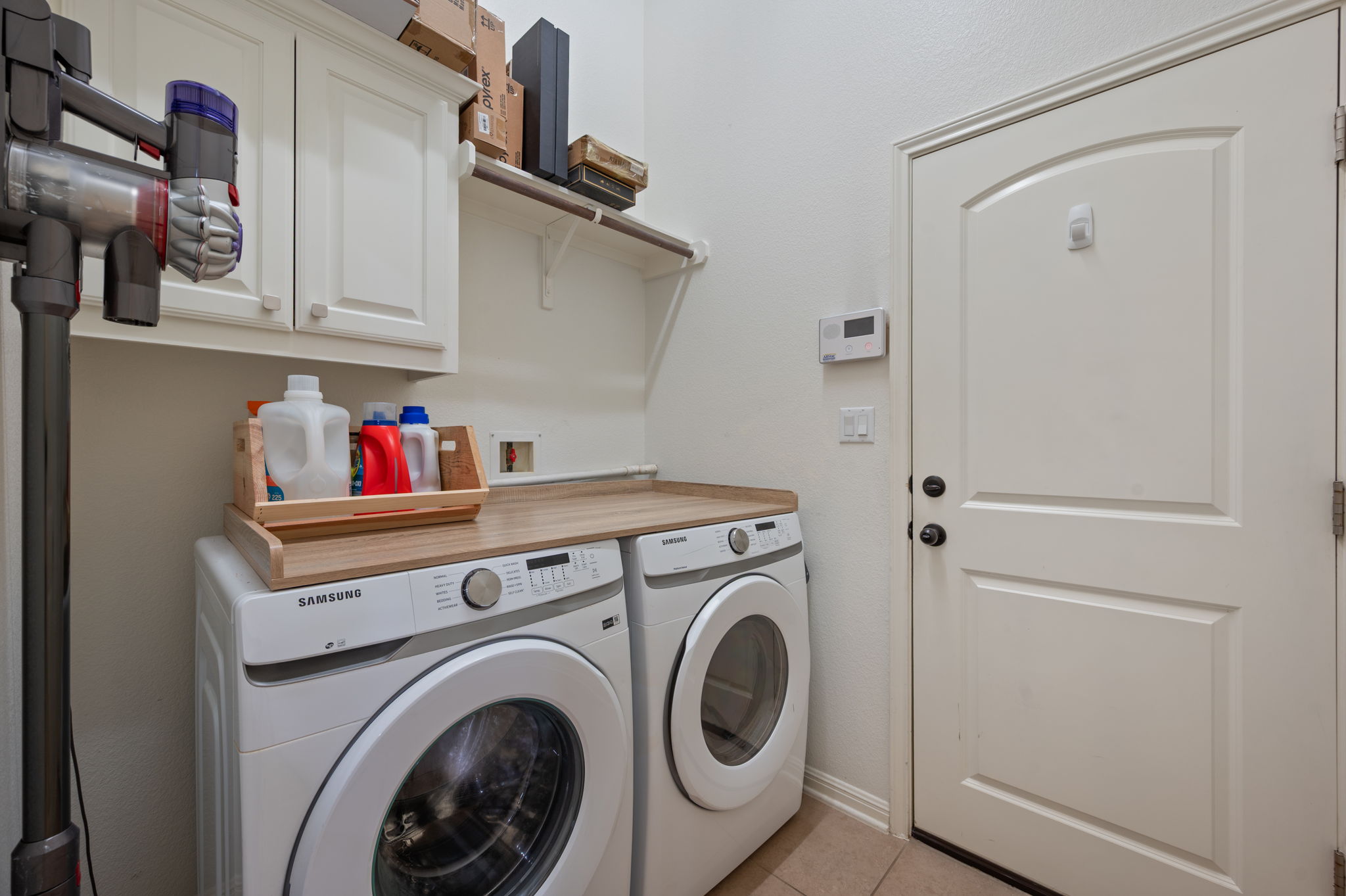 4220 Tambre Bend Austin, TX 78738 - Photo 24 of 28 Laundry room featuring cabinet space, light tile patterned floors, and washing machine and dryer
