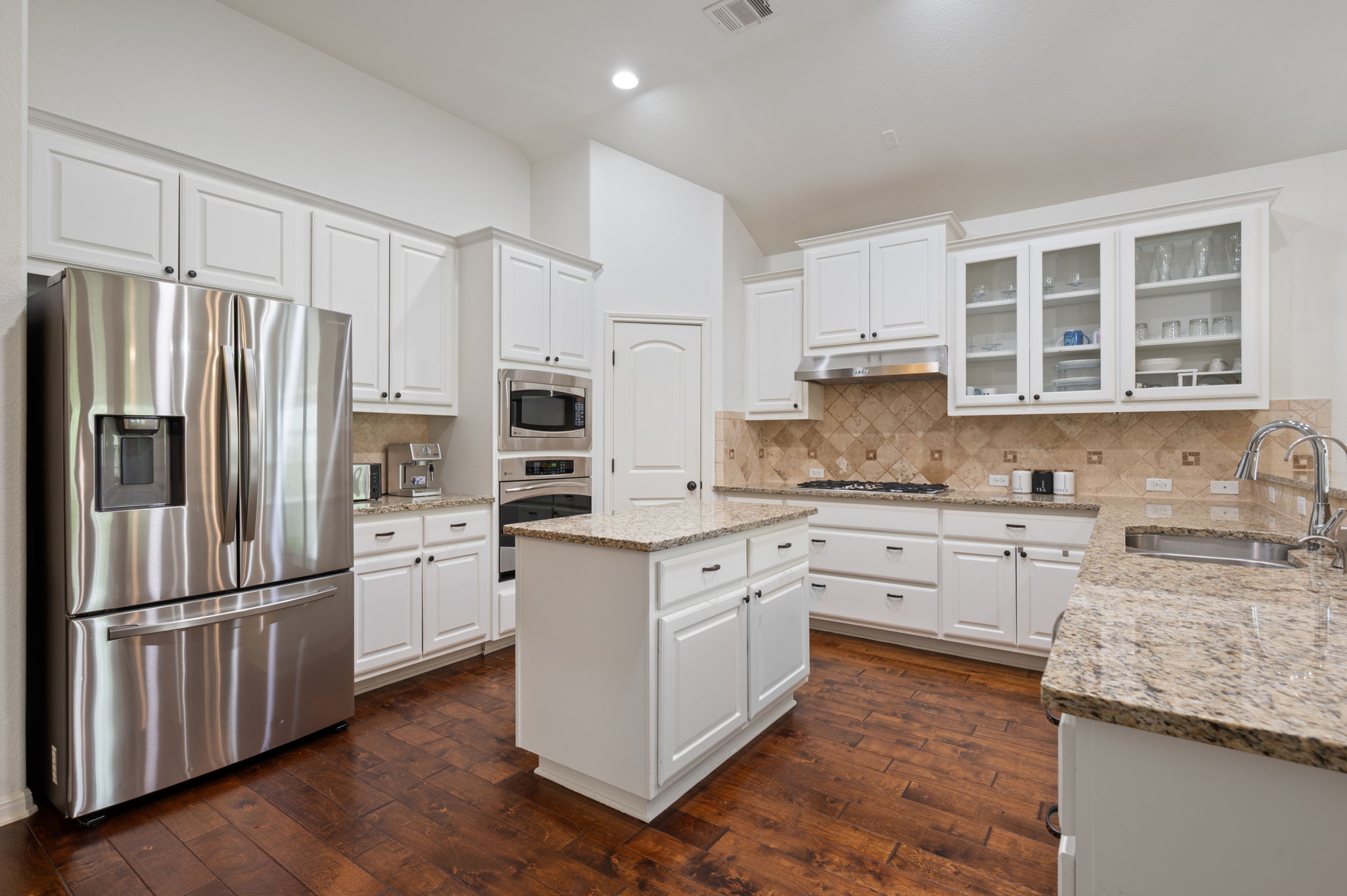 4220 Tambre Bend Austin, TX 78738 - Photo 7 of 28 Kitchen with stainless steel appliances, white cabinetry, dark wood-style flooring, a center island, and recessed lighting