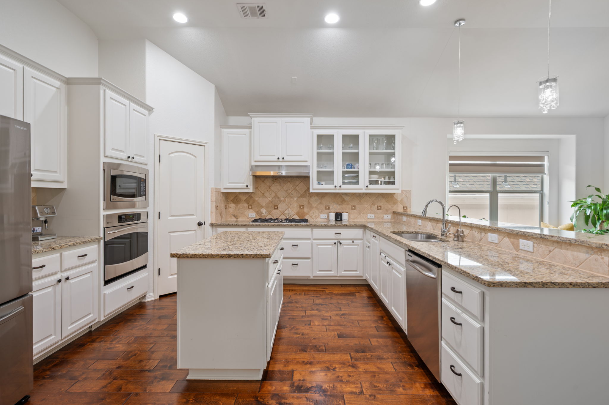 4220 Tambre Bend Austin, TX 78738 - Photo 8 of 28 Kitchen with glass fronted cabinets, white cabinetry, a kitchen island, and dark wood-style floors