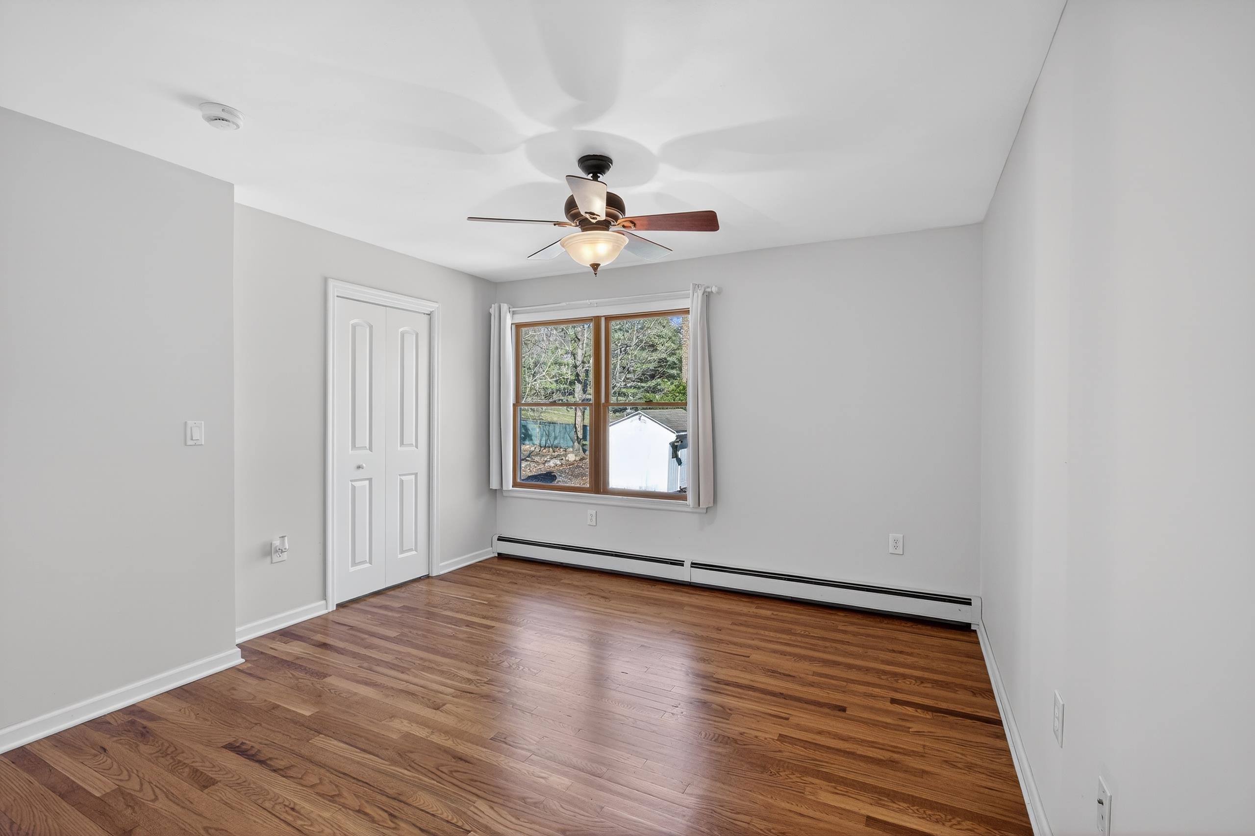 33 Georgia Drive Wayne, NJ 07470 - Photo 14 of 36 a view of an empty room with wooden floor and a window
