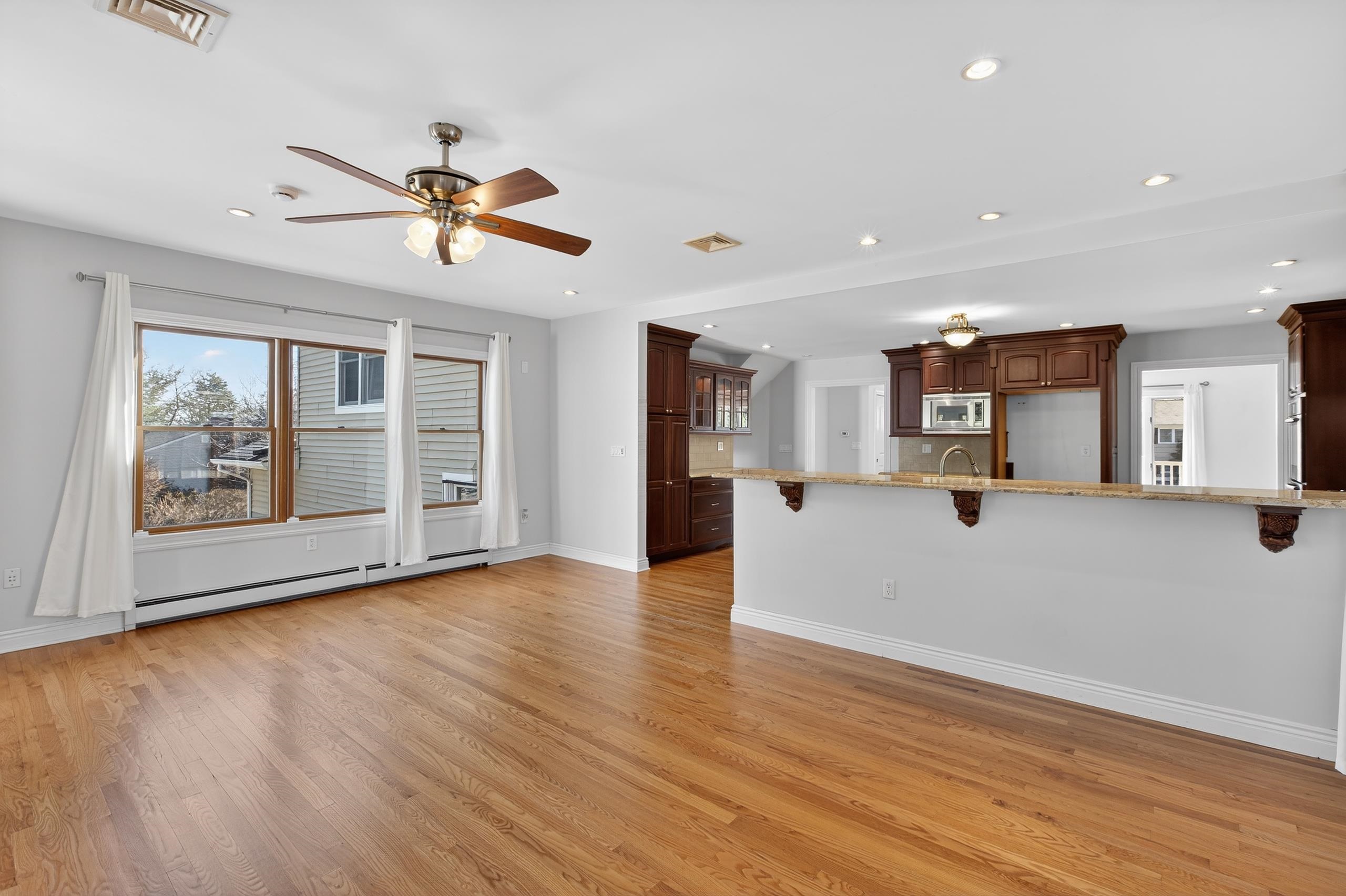 33 Georgia Drive Wayne, NJ 07470 - Photo 9 of 36 a view of a living room with wooden floor and a ceiling fan