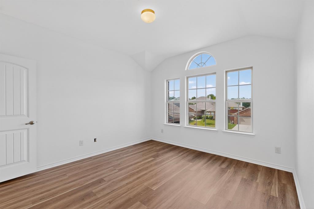 426 Harding Lane Lavon, TX 75166 - Photo 35 of 40 Vaulted ceiling room featuring wood-finish flooring, white baseboards, and a white paneled interior door
