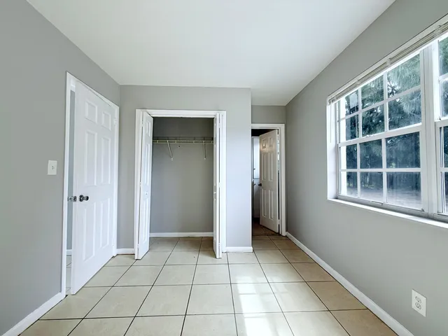 a view of an empty room with window and cabinet
