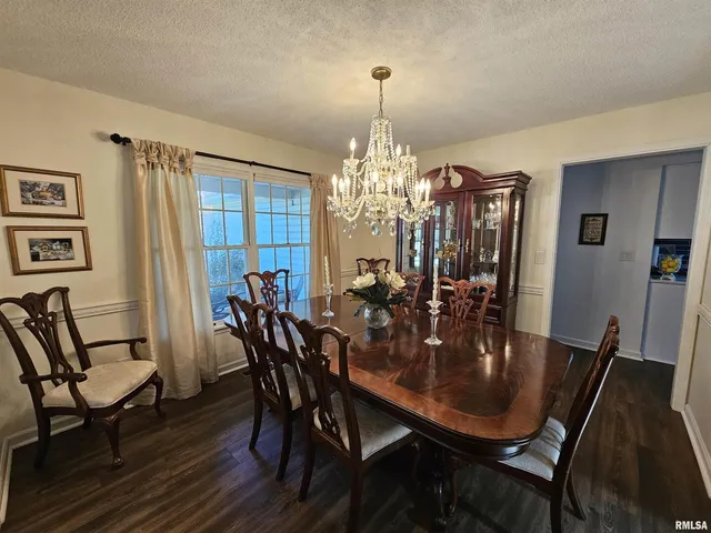 a view of a dining room with furniture and chandelier