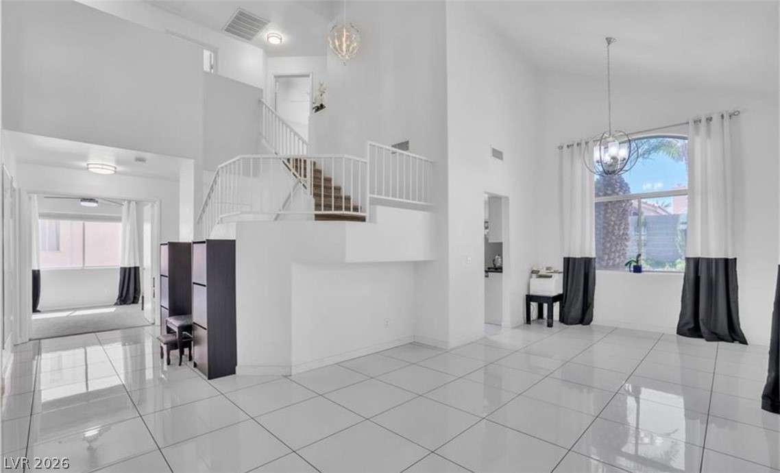 6429 Winding Ridge Las Vegas, NV 89156 - Photo 15 of 22 An open-concept living area with soaring ceilings and gleaming tile flooring offers an inviting atmosphere.