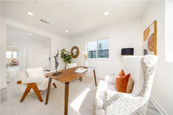 a living room with stainless steel appliances kitchen island a table and chairs in it