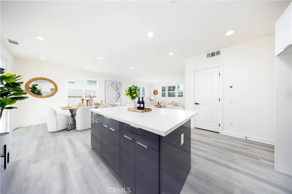 a bedroom with a bed and a lamp on table with wooden floor