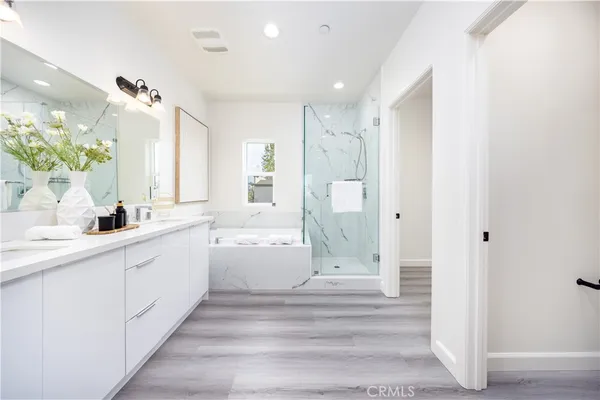 a bathroom with a double vanity sink a mirror and a bathtub
