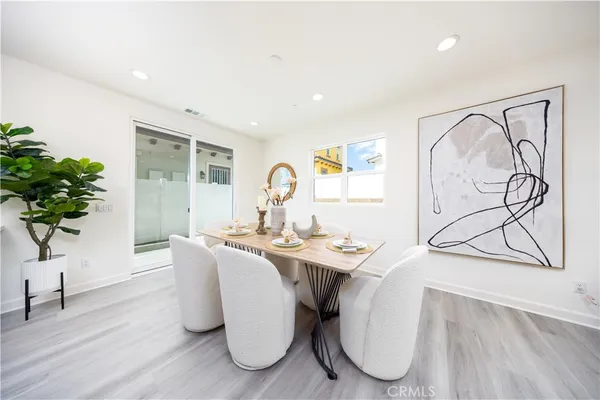 a kitchen with stainless steel appliances kitchen island granite countertop a sink a stove a dining table and chairs