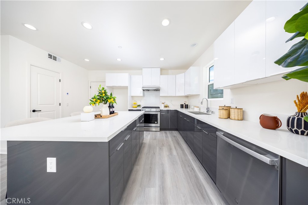 1371 Point Loma Place Walnut, CA 91789 - Photo 5 of 33 a large white kitchen with lots of counter space a sink wooden cabinets and appliances