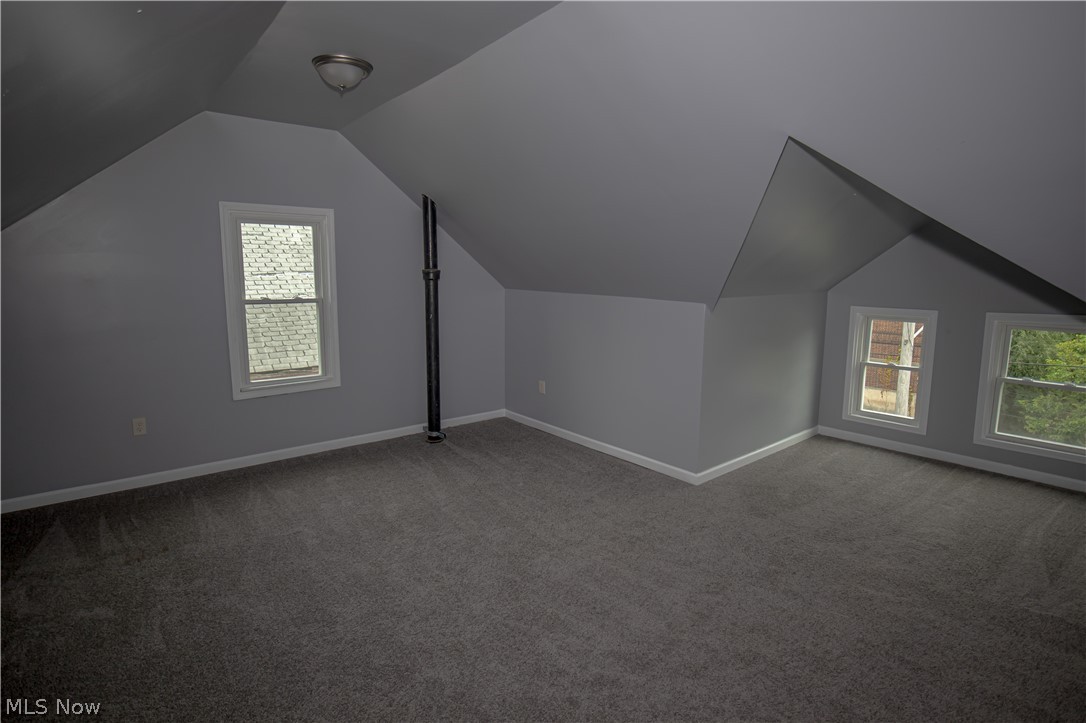 9505 Aetna Road Cleveland, OH 44105 - Photo 22 of 25 Bonus room with lofted ceiling and dark carpet