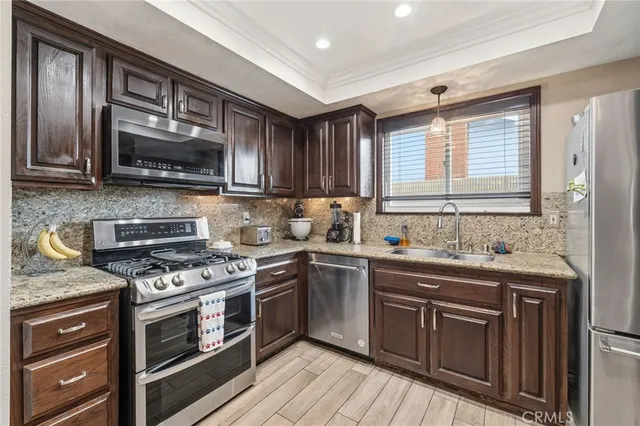 a kitchen with stainless steel appliances wooden floor dining table and chairs