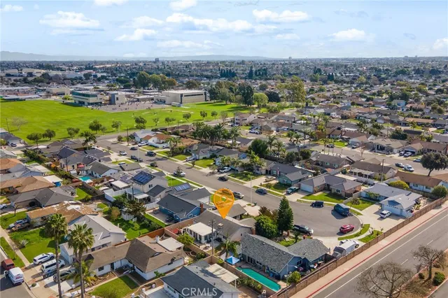 an aerial view of residential houses with outdoor space and parking