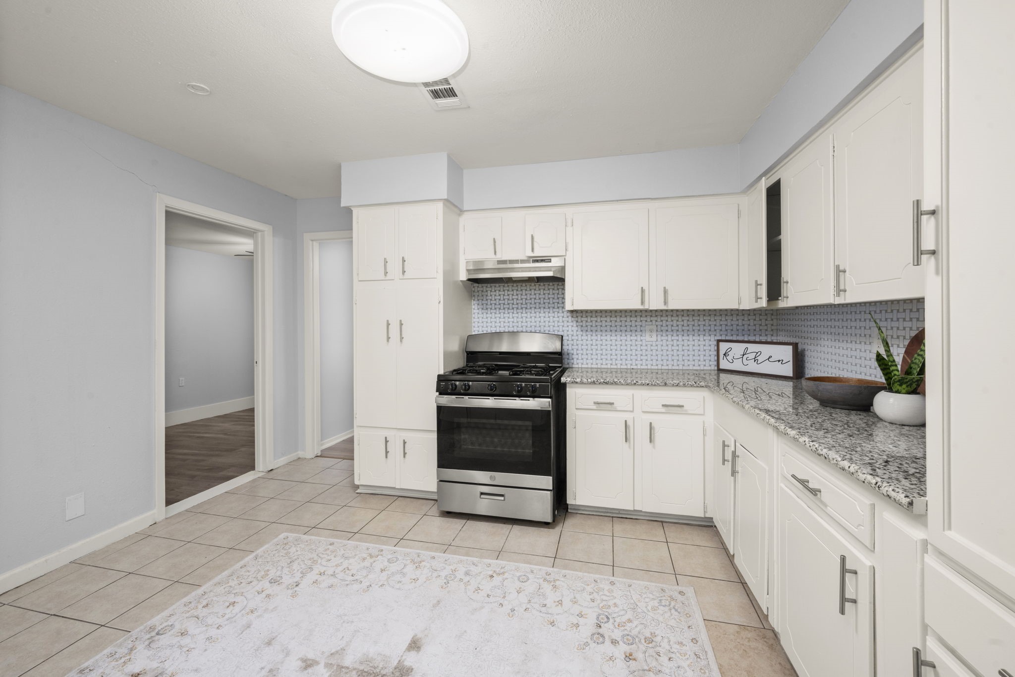 4326 Akard Street Houston, TX 77047 - Photo 17 of 43 a kitchen with granite countertop a stove sink and cabinets