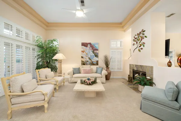 a living room with furniture a fireplace and a chandelier