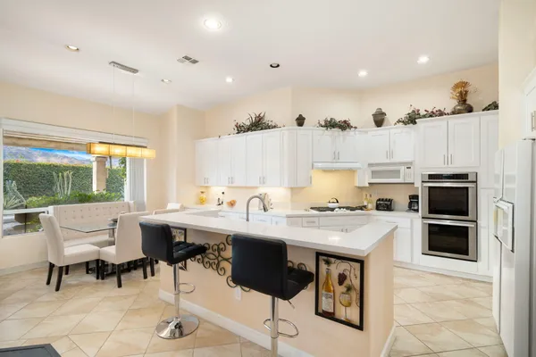 a kitchen with a stove a refrigerator and a dining table