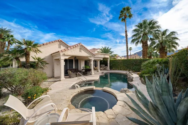 a view of a patio with table and chairs potted plants and palm tree