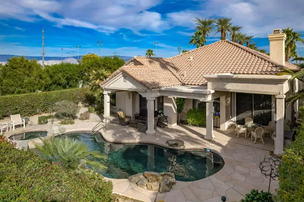 a view of a house with backyard sitting area and pool