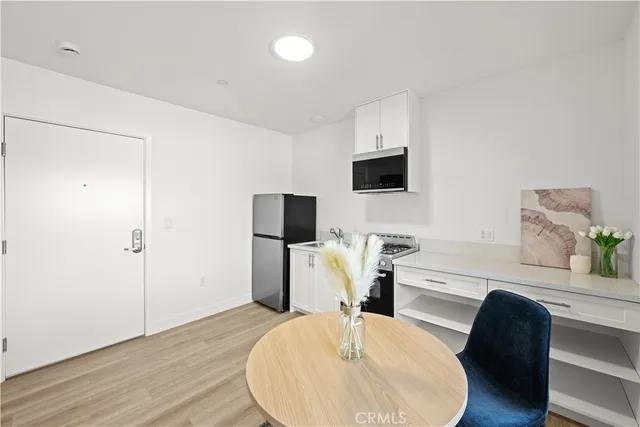 a work room with furniture a flat screen tv and a wooden floor