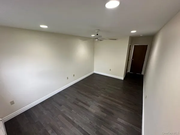 an empty room with wooden floor and mirror