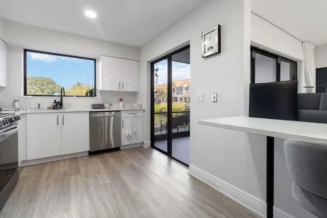 a kitchen with a sink a refrigerator and cabinets