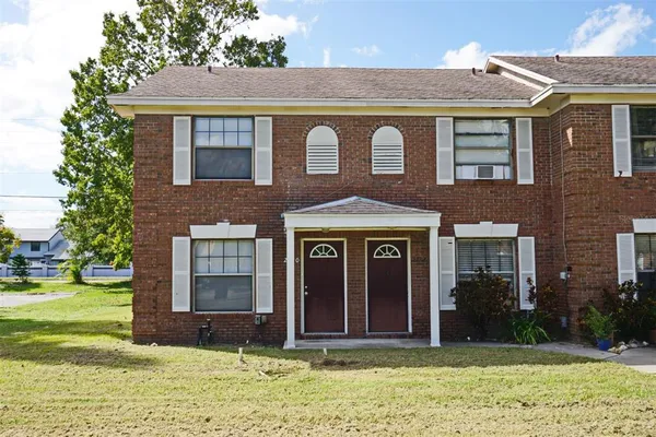 a view of a brick house with a yard