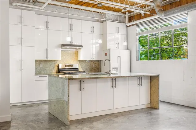 a kitchen with a sink a counter top space and stainless steel appliances
