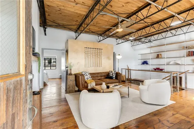 a view of a hallway with wooden floor and a kitchen