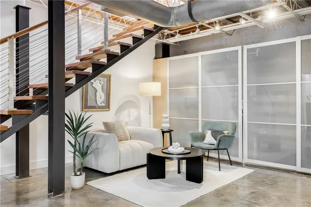a living room with furniture a large window and potted plants