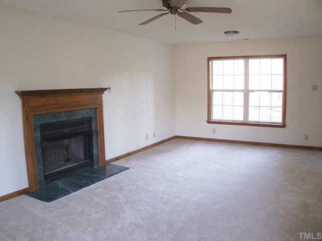 809 West C Street Butner, NC 27509 - Photo 3 of 12 an empty room with a fireplace and windows