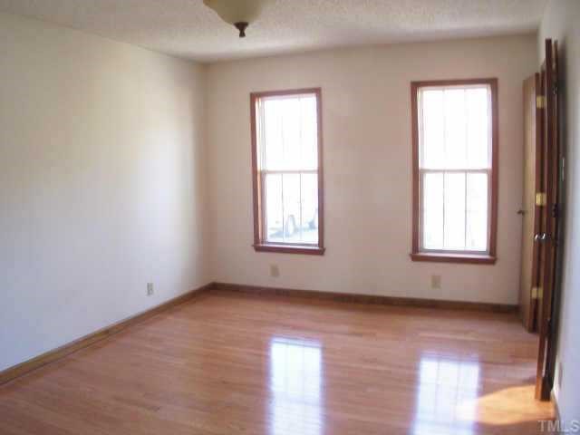 809 West C Street Butner, NC 27509 - Photo 7 of 12 an empty room with wooden floor and windows