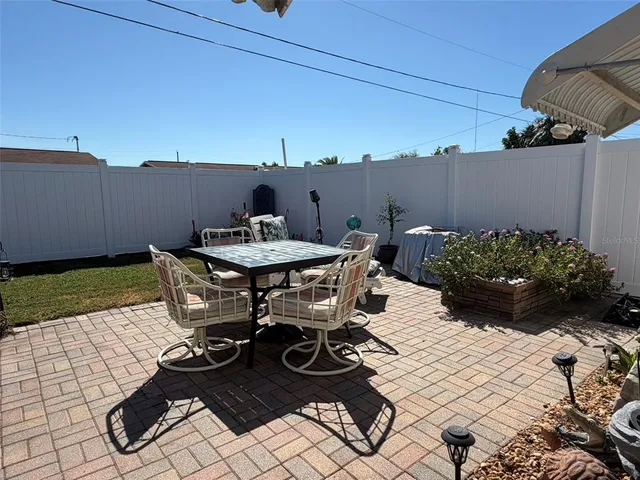 a view of a patio with table and chairs and potted plants