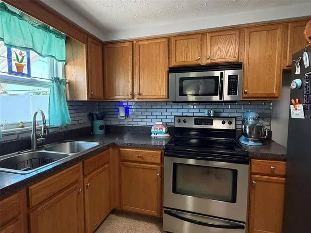 a kitchen with granite countertop cabinets stainless steel appliances and a sink