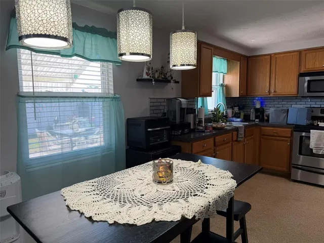 a kitchen with a kitchen island a stove a table and chairs in it