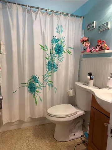 a bathroom with a toilet and a shower curtain