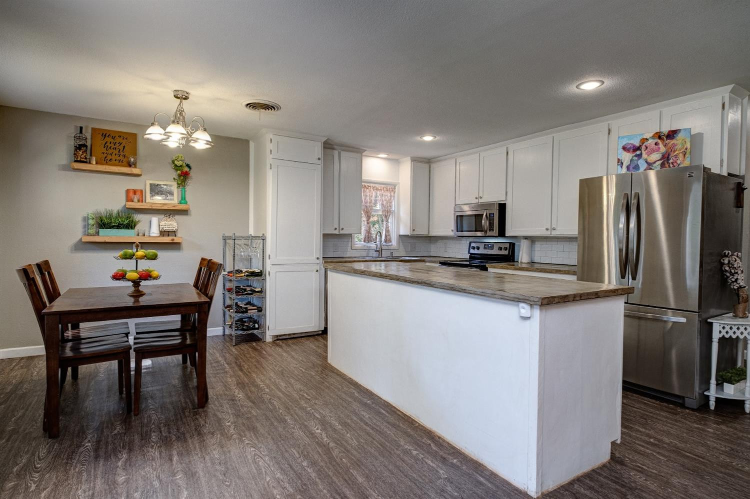5209 16th Street Lubbock, TX 79416 - Photo 12 of 23 a kitchen with stainless steel appliances granite countertop a dining table chairs refrigerator microwave and cabinets